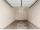 Empty two-car garage with concrete floors, and two entry doors at 14239 W Port Royale Ln, Surprise, AZ 85379