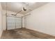 Empty two-car garage with concrete floors and an automatic door opener at 14239 W Port Royale Ln, Surprise, AZ 85379
