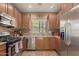 Well-equipped kitchen with stainless steel appliances, granite countertops, and wood cabinets at 14239 W Port Royale Ln, Surprise, AZ 85379