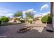 Expansive backyard with pavers, desert landscaping, mature trees, and a charming flower bed, offering privacy and space at 14722 W Lucas Ln, Surprise, AZ 85374