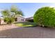 View of the home's lovely backyard with mature trees and landscaping at 14722 W Lucas Ln, Surprise, AZ 85374