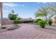 Spacious backyard with brick patio, green grass, mature trees, charming flower bed and a covered patio with gazebo at 14722 W Lucas Ln, Surprise, AZ 85374