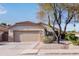 Charming single story home featuring a tan facade, a two-car garage, and low maintenance desert landscaping at 14722 W Lucas Ln, Surprise, AZ 85374