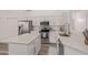 Bright kitchen with white cabinets, stainless steel appliances, and stone countertops on a center island at 14722 W Lucas Ln, Surprise, AZ 85374