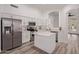 Bright kitchen with stainless steel appliances, white cabinets, stone countertops and a center island at 14722 W Lucas Ln, Surprise, AZ 85374