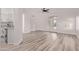 Bright living room featuring wood-look flooring, white walls and an open floor plan to the kitchen at 14722 W Lucas Ln, Surprise, AZ 85374