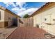 The backyard shows a red rock landscape enclosed by block wall, a wooden gate, and the home's exterior at 15328 W Memory Ln, Surprise, AZ 85374