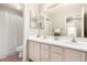 Bright bathroom featuring a double sink vanity, large mirror, and neutral wall color at 15328 W Memory Ln, Surprise, AZ 85374