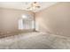 Bright bedroom featuring high ceilings, large windows, neutral carpet, and a ceiling fan at 15328 W Memory Ln, Surprise, AZ 85374