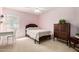 Cozy bedroom featuring a classic wood bed frame, desk, and large antique armoire with matching carpet at 15328 W Memory Ln, Surprise, AZ 85374