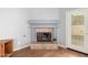 Close-up of a cozy tile fireplace with rustic mantle in an open-concept living area and wood-look floor at 15328 W Memory Ln, Surprise, AZ 85374