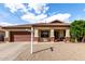 Inviting front exterior featuring a well-maintained lawn, desert landscaping, and covered entryway at 15328 W Memory Ln, Surprise, AZ 85374