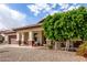 Attractive home showcasing a covered porch area with desert landscaping, mature trees, and a two-car garage at 15328 W Memory Ln, Surprise, AZ 85374