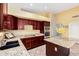 Modern kitchen boasts granite countertops, cherry wood cabinetry, and stainless steel double oven at 15328 W Memory Ln, Surprise, AZ 85374