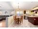 Spacious kitchen featuring stainless steel appliances, granite counters, and wooden dining table with chandelier at 15328 W Memory Ln, Surprise, AZ 85374