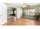 Inviting living room with two-tone green walls, modern ceiling fan, and bright natural light from large window at 15328 W Memory Ln, Surprise, AZ 85374
