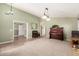 Open living room with olive green walls, carpet, piano, and arched doorways for ease of transition at 15328 W Memory Ln, Surprise, AZ 85374