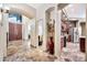 The spacious home foyer boasts an intricate stone-tile floor and leads to the kitchen through the archway at 15413 S 31St Pl, Phoenix, AZ 85048