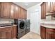 The laundry room provides built-in wood cabinets, a sink, granite countertops, and a front-load washer and dryer at 15413 S 31St Pl, Phoenix, AZ 85048