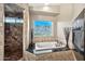 Luxurious bathroom with a soaking tub, tiled shower, and natural light at 15413 S 31St Pl, Phoenix, AZ 85048