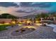 Desert oasis backyard with a fire pit, spa, beautiful stone hardscape, and stunning mountain views at 15413 S 31St Pl, Phoenix, AZ 85048