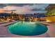 Sparkling pool with baja shelf, in-ground spa, lush landscaping, and mountain views at dusk at 15413 S 31St Pl, Phoenix, AZ 85048