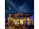 Nighttime view of the backyard featuring a covered patio with string lights, a pool, and outdoor furniture at 15418 W Surrey Dr, Surprise, AZ 85379