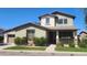 Charming two-story home featuring a welcoming front porch, beautiful landscaping, and a well-manicured lawn at 15418 W Surrey Dr, Surprise, AZ 85379