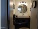 Stylish bathroom featuring a modern round mirror, vessel sink, and contemporary lighting fixtures at 1621 E Maryland Ave, Phoenix, AZ 85016