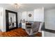 Relaxing sitting area boasts wood floors, large mirror, chair, desk, and white curtains for a cozy retreat at 1621 E Maryland Ave, Phoenix, AZ 85016