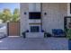 Beautiful brick fireplace, TV, and seating on a large covered backyard patio at 16322 E Fairview St, Gilbert, AZ 85295