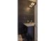Elegant bathroom with a modern vanity, stunning black marble wall, and designer lighting fixture at 16322 E Fairview St, Gilbert, AZ 85295