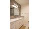 Bright bathroom featuring a white vanity with quartz countertop, modern fixtures, and wood-look tiling around the mirror at 16322 E Fairview St, Gilbert, AZ 85295