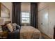 Comfortable bedroom with a large bed, accent pillows, soft throw, and stylish window treatments at 16322 E Fairview St, Gilbert, AZ 85295