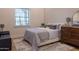 Serene bedroom with cozy bed, textured walls, and dresser, offering a peaceful retreat with ample natural light at 16322 E Fairview St, Gilbert, AZ 85295