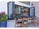 Outdoor covered seating area with access to kitchen bar through open windows at 16322 E Fairview St, Gilbert, AZ 85295