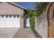 Charming exterior view showcasing a garage, a walkway leading to a door, and lush greenery at 16322 E Fairview St, Gilbert, AZ 85295