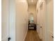 Hallway with wood-look flooring, decorative table, mirror, and white doors at 16322 E Fairview St, Gilbert, AZ 85295