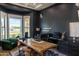 Stylish home office featuring dark blue walls, a large window, and a rustic wooden desk, ideal for working from home at 16322 E Fairview St, Gilbert, AZ 85295