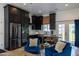 Modern kitchen with stainless steel appliances, sleek black cabinetry, and a dining area, perfect for cooking and entertaining at 16322 E Fairview St, Gilbert, AZ 85295