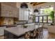Gourmet kitchen featuring modern appliances, a center island with seating, and elegant lighting fixtures at 16322 E Fairview St, Gilbert, AZ 85295