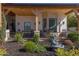 Covered porch with ample seating, stone detailing, and manicured landscaping enhancing the outdoor living experience at 16322 E Fairview St, Gilbert, AZ 85295