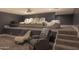 Basement theater room with tiered seating, projector, and comfortable chairs at 16322 E Fairview St, Gilbert, AZ 85295