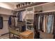 Well-organized walk-in closet with built-in shelves, clothing racks, bench, and a hamper, maximizing storage space at 16322 E Fairview St, Gilbert, AZ 85295
