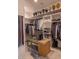 Spacious walk-in closet featuring custom shelving, hanging rods, a bench, and a laundry basket for optimal organization at 16322 E Fairview St, Gilbert, AZ 85295