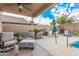 Covered patio area with comfortable seating and views of the backyard and pool at 16424 W Cottonwood St, Surprise, AZ 85388
