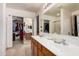 Bathroom with a double vanity, large mirror and access to a walk-in closet at 16424 W Cottonwood St, Surprise, AZ 85388