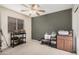 Bright bedroom with neutral carpet, a ceiling fan, and a dark accent wall at 16424 W Cottonwood St, Surprise, AZ 85388