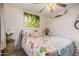 Comfortable bedroom with floral bedding, bright art, a ceiling fan, and a closet at 16424 W Cottonwood St, Surprise, AZ 85388