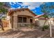 Inviting home with a cozy front porch, beautiful desert landscaping, and mature shade trees at 16424 W Cottonwood St, Surprise, AZ 85388